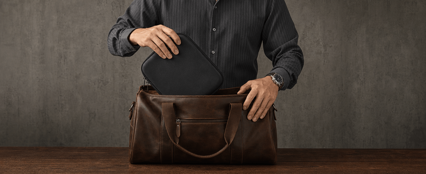 A man holds open a brown leather duffel travel bag, showing a black zippered travel watch case pouch inside.