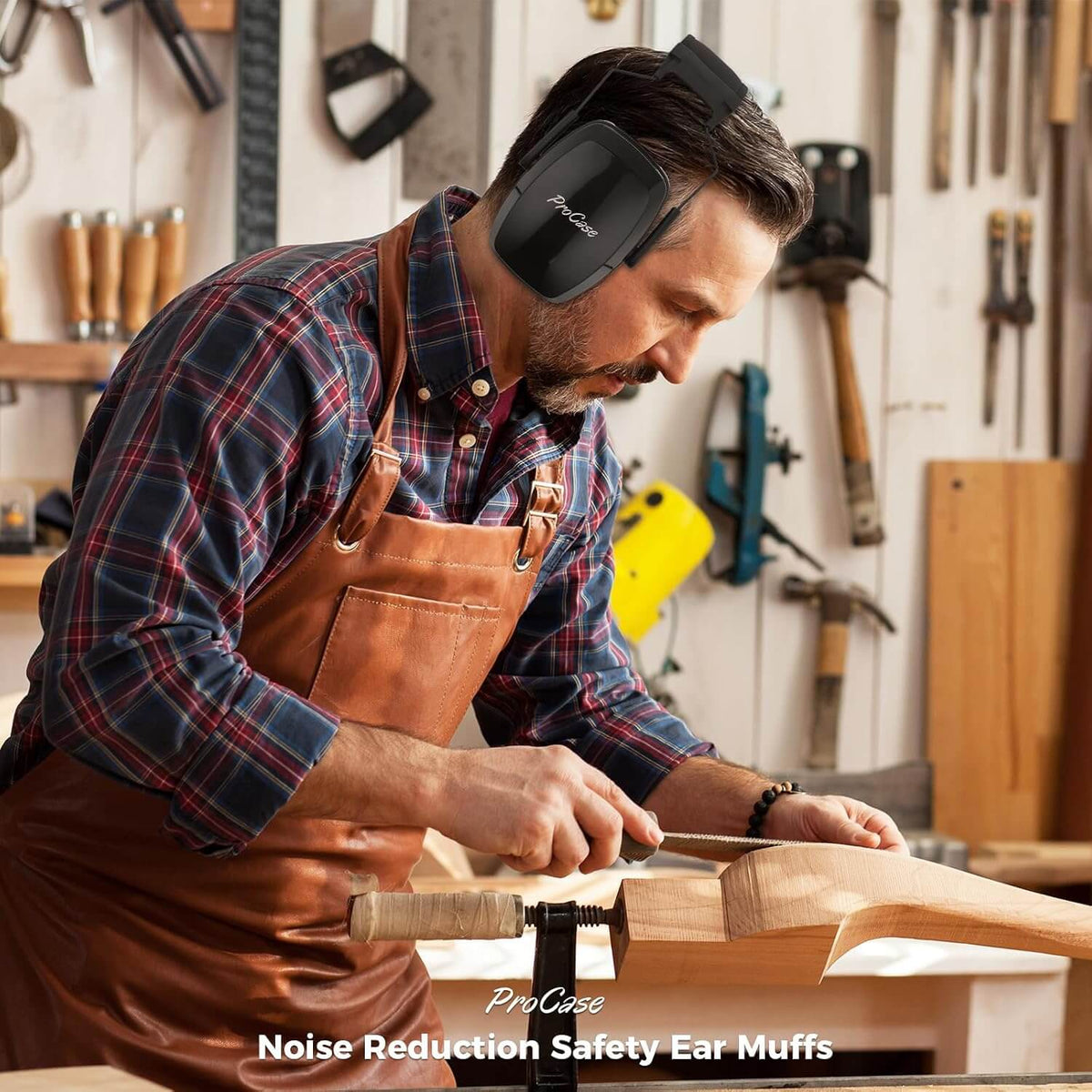 Man wearing noise reduction safety ear muffs in a workshop.