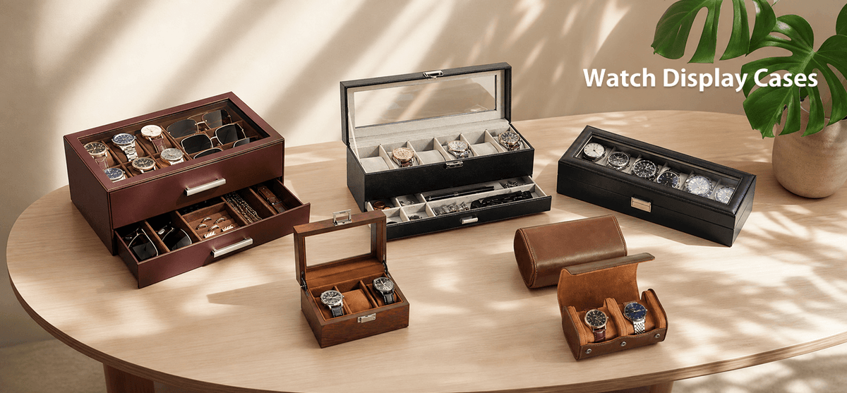 A collection of wooden and leather watch display cases in various sizes and styles. The cases feature different designs including multi-compartment wooden boxes, glass-top watch towers, and leather travel cases, each holding several watches.