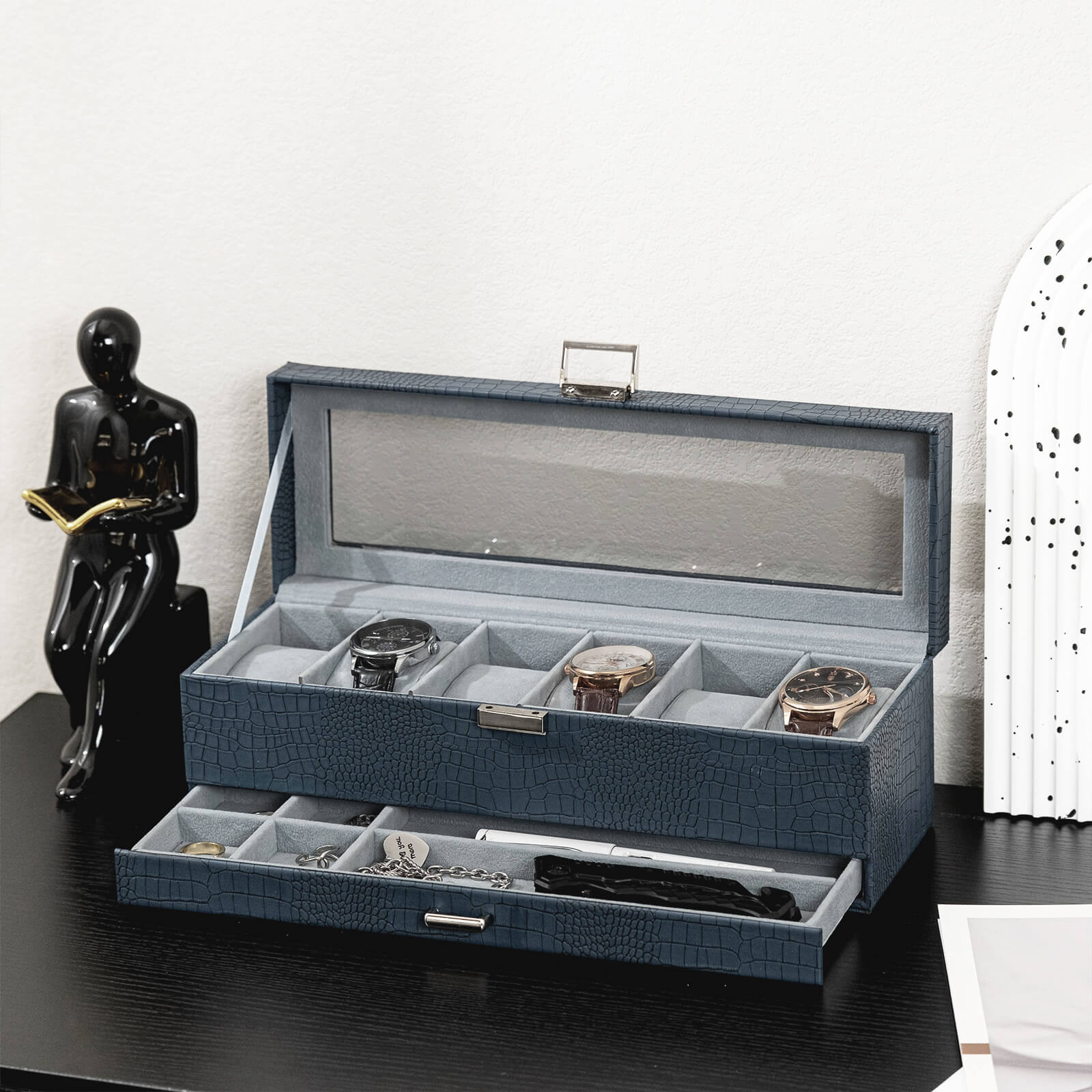 Blue jewelry box with watches and jewelry on a dark surface