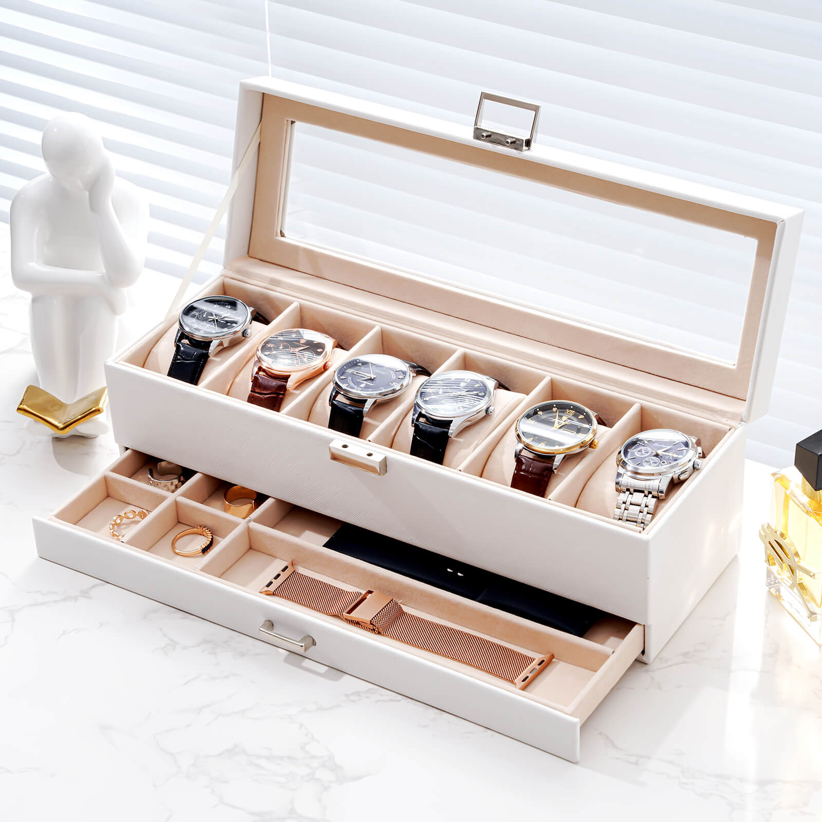 White jewelry box with watches and accessories on a white surface