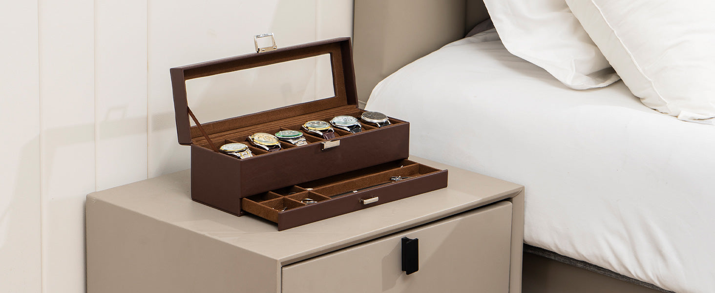 Person organizing watches in a wooden display case on a wooden desk.