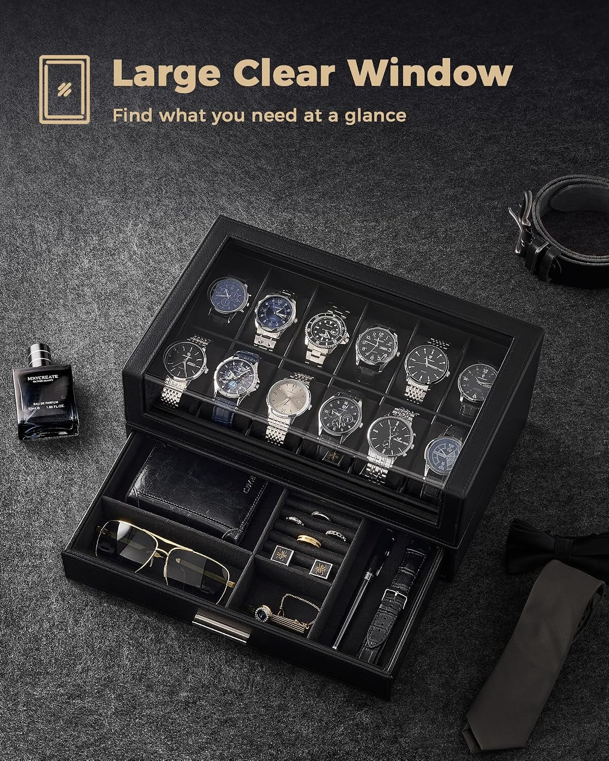 A black watch storage box with a large clear window is shown open on a dark textured surface, displaying multiple wristwatches, along with accessories inside. 