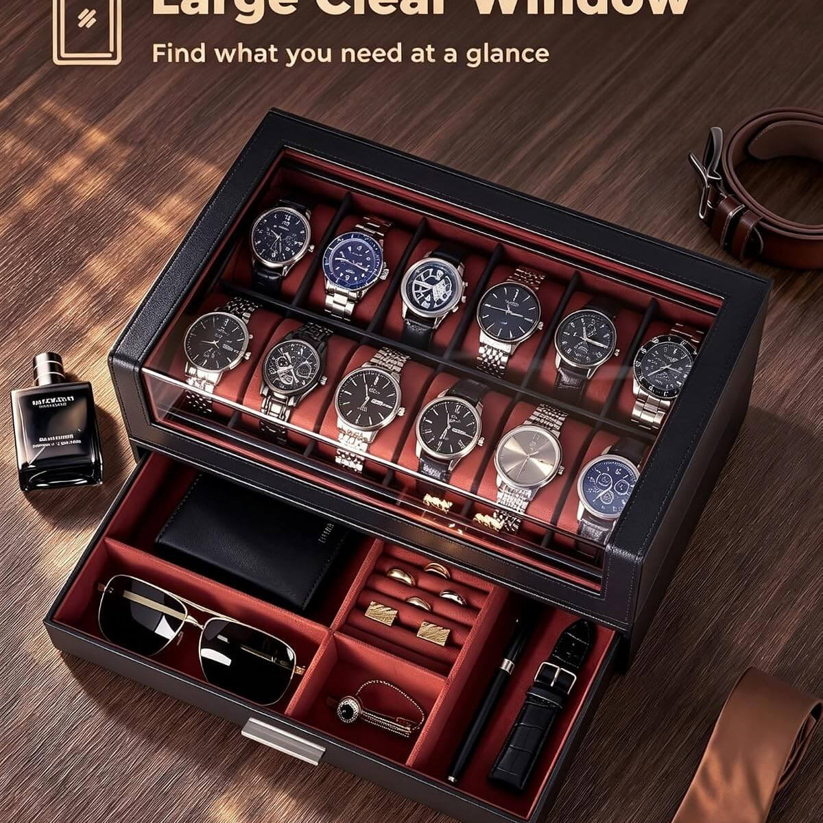 A luxury watch storage box with a clear glass top window and an open lower drawer, displayed on a wooden table. The box is black with a red interior and holds multiple wristwatches, sunglasses, a watch, and accessories.
