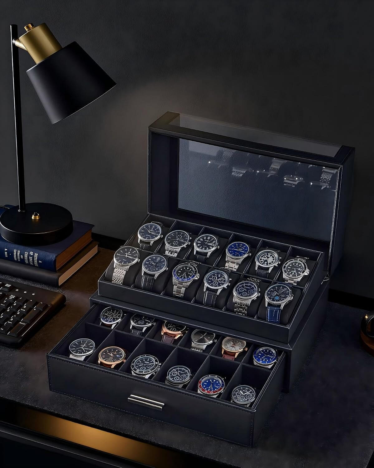 A black watch storage box with a  lid, shown open on a dark desk. The box contains multiple rows of wristwatches in divided compartments