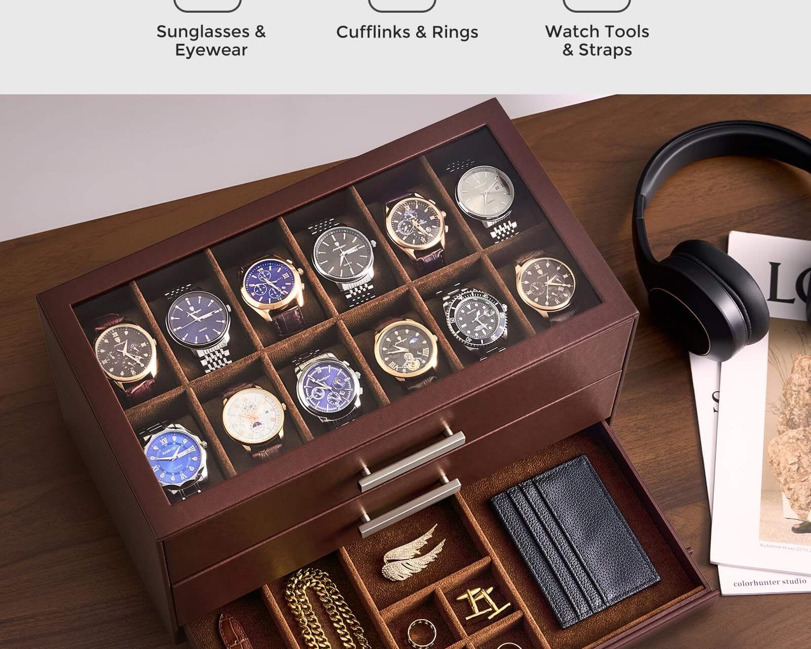 A wooden all-in-one watch organizer box with a glass top, shown open on a desk. The upper section holds multiple wristwatches, and the open drawer contains accessories including a brown leather strap, gold-tone chain, rings, and a black card holder.