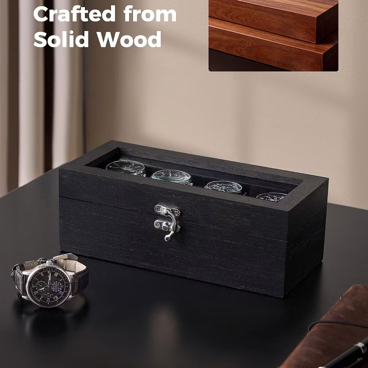 A dark wood watch storage box with a transparent top, shown on a black tabletop with a wristwatch beside it. A small inset shows the wood grain detail, and text reads 'Crafted from Solid Wood.