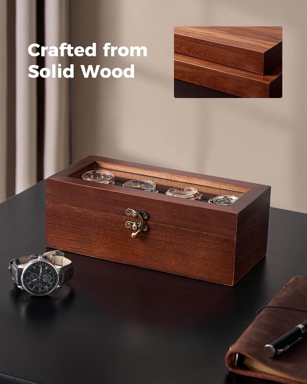 A rectangular wooden watch box with a transparent top and four visible watch faces, placed on a dark tabletop. A wristwatch and a notebook are nearby as props, and the text 'Crafted from Solid Wood' appears in the upper left with a small inset showing the wood grain detail.
