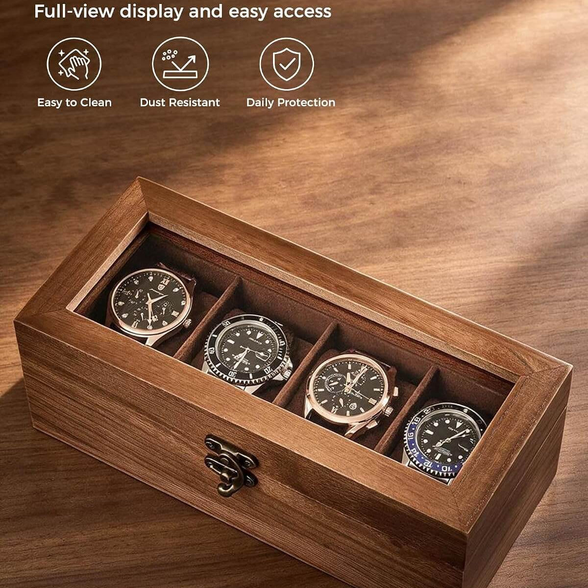 A wooden watch box with a clear glass lid, shown open on a wooden surface. Inside are four watches, one in each compartment.