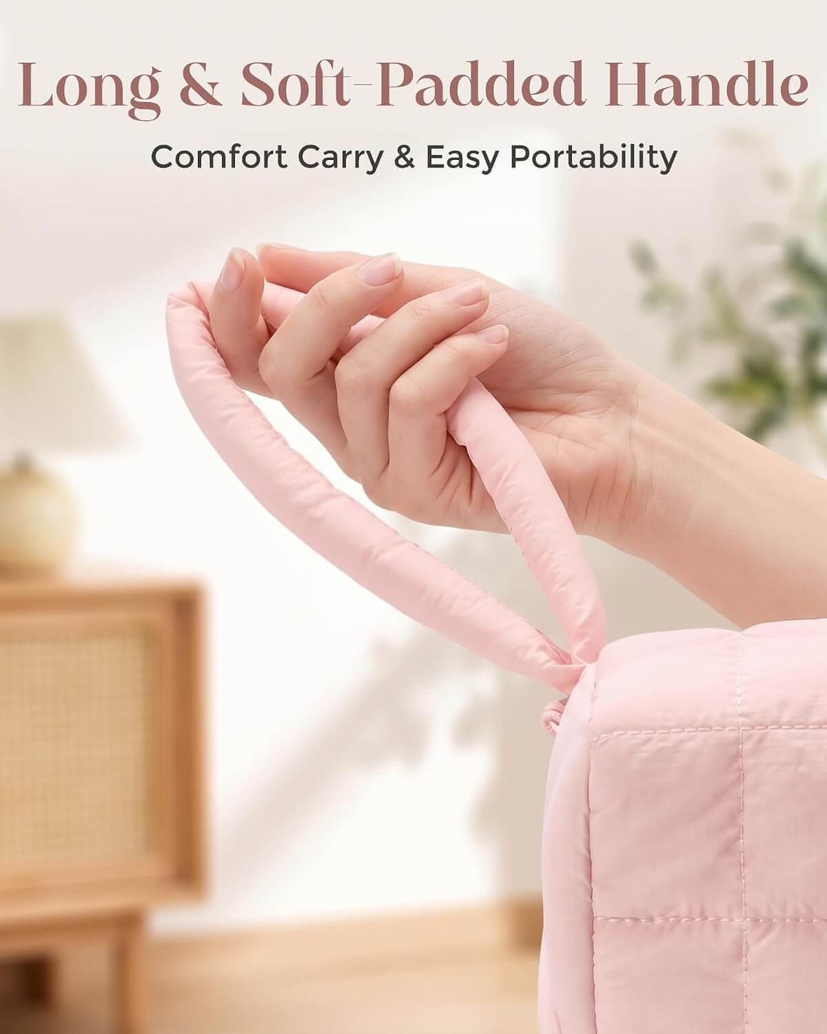 A close-up of a person's hand holding a long, soft-padded pink hand strap attached to a puffy tech pouch, with text at the top reading 'Long & Soft-Padded Handle' and 'Comfort Carry & Easy Portability.'.