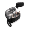 A black quilted travel puffy tech pouch shown open, filled with cosmetics, earbuds, and accessories, with a smaller closed view of the same pouch above on a white background.